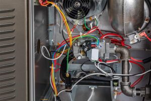 Inside view of a gas furnace with colorful wiring and components