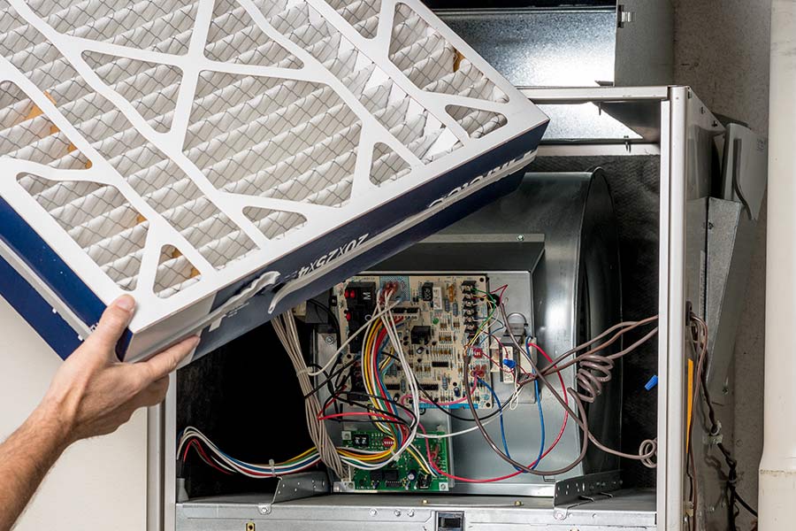 HVAC technician replacing an air filter during heating repair service in Arlington, TX